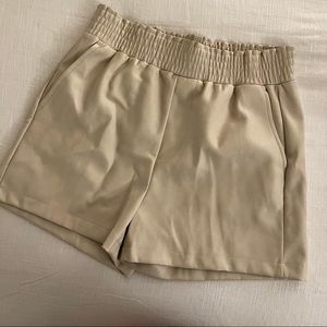cream leather shorts.